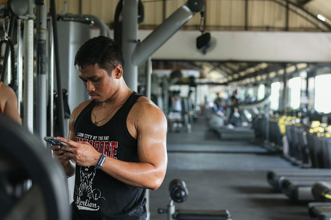 Un coach regarde son téléphone à la salle de sport.